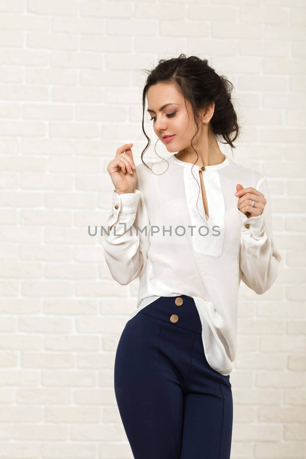 portrait of a beautiful happy brunette woman in a white blouse