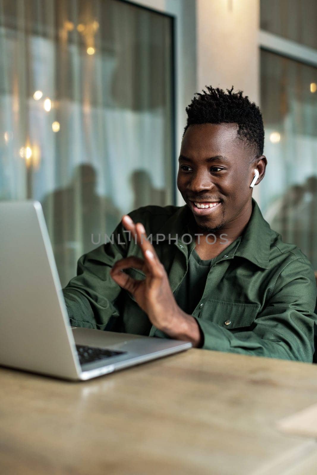 Handsome african american man using computer and smiling. Online video chat with friends