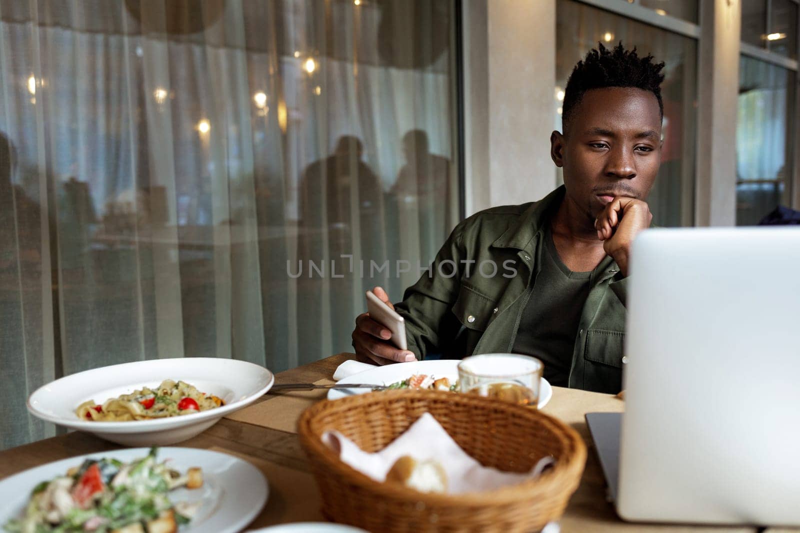 young african american man using laptop in cafe