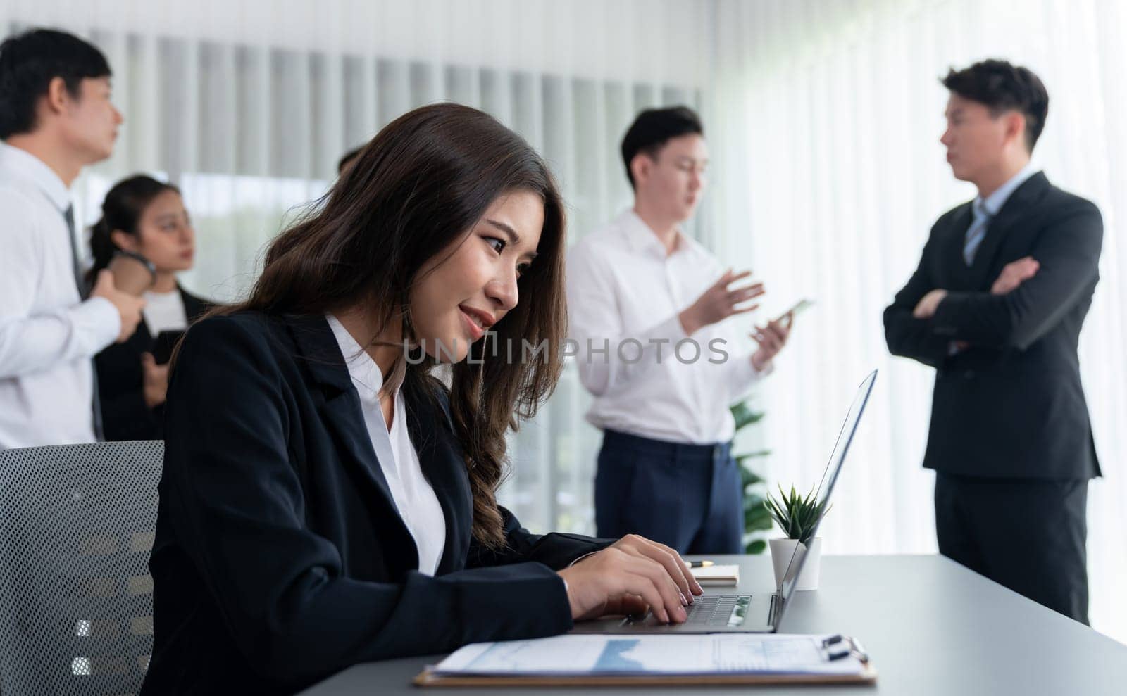 Focus portrait of female manger, businesswoman in the harmony meeting room with blurred of colleagues working together, analyzing financial paper report and dashboard data in background.