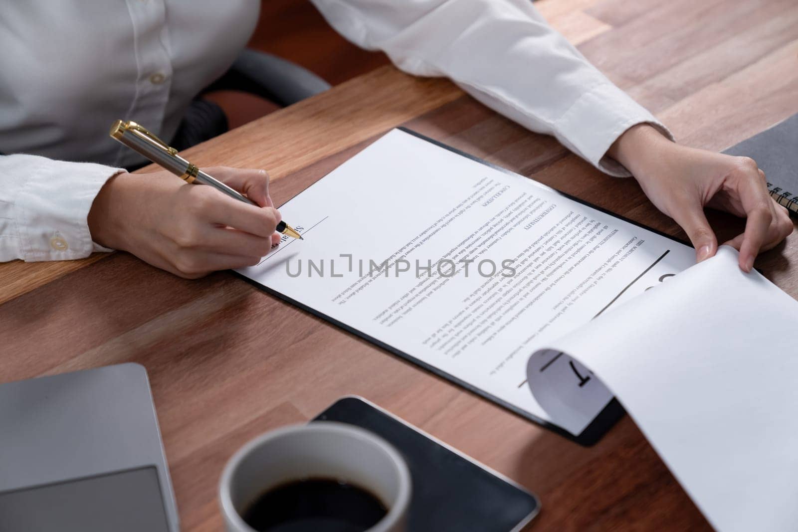 Closeup hand signing contract document with pen, sealing business deal with signature. Businesspeople finalizing business agreement by writing down signature on contract paper. Enthusiastic