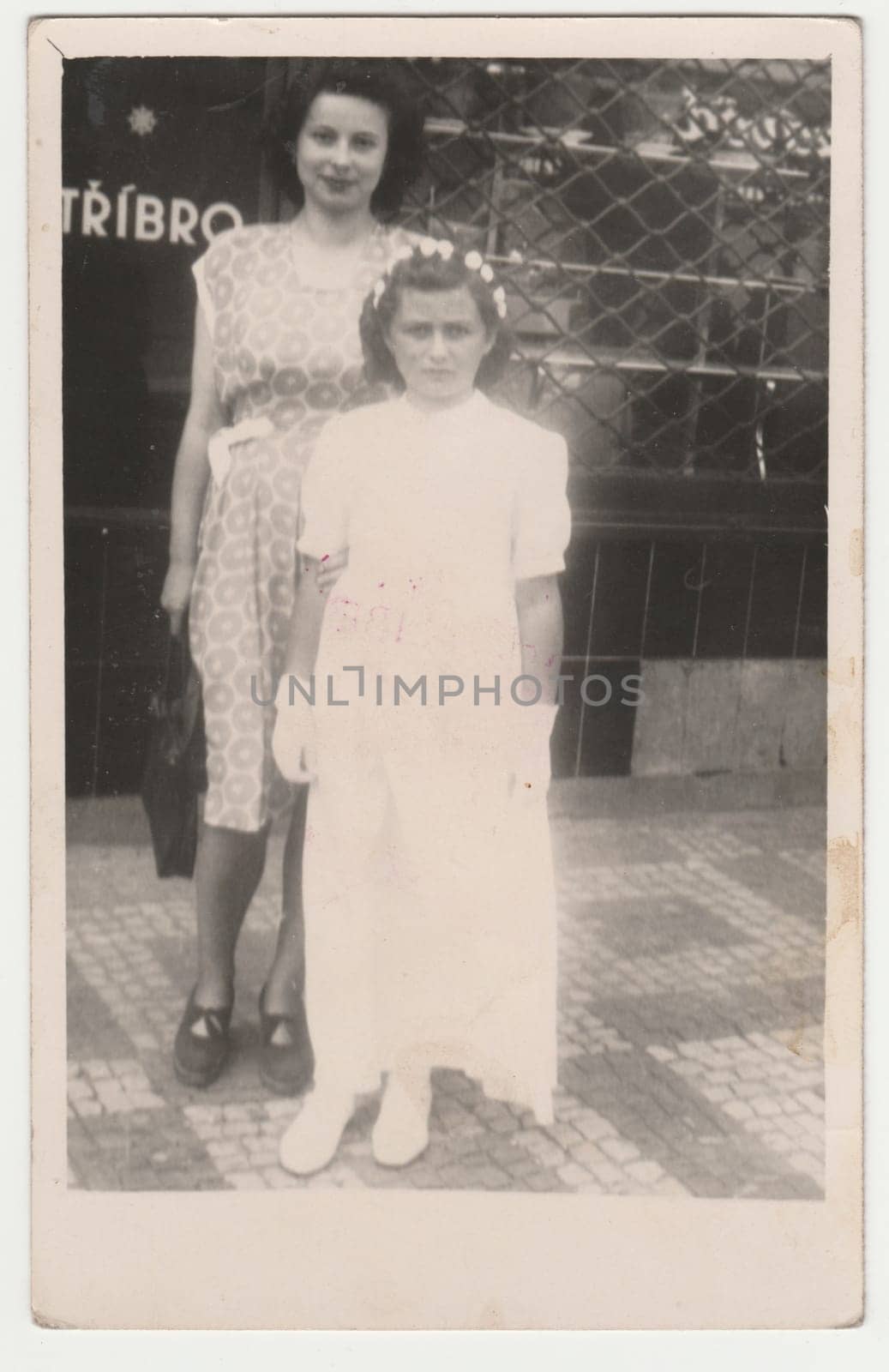 Vintage photo shows mother and daughter after her first communion. Retro black and white photography. Circa 1950s. by roman_nerud