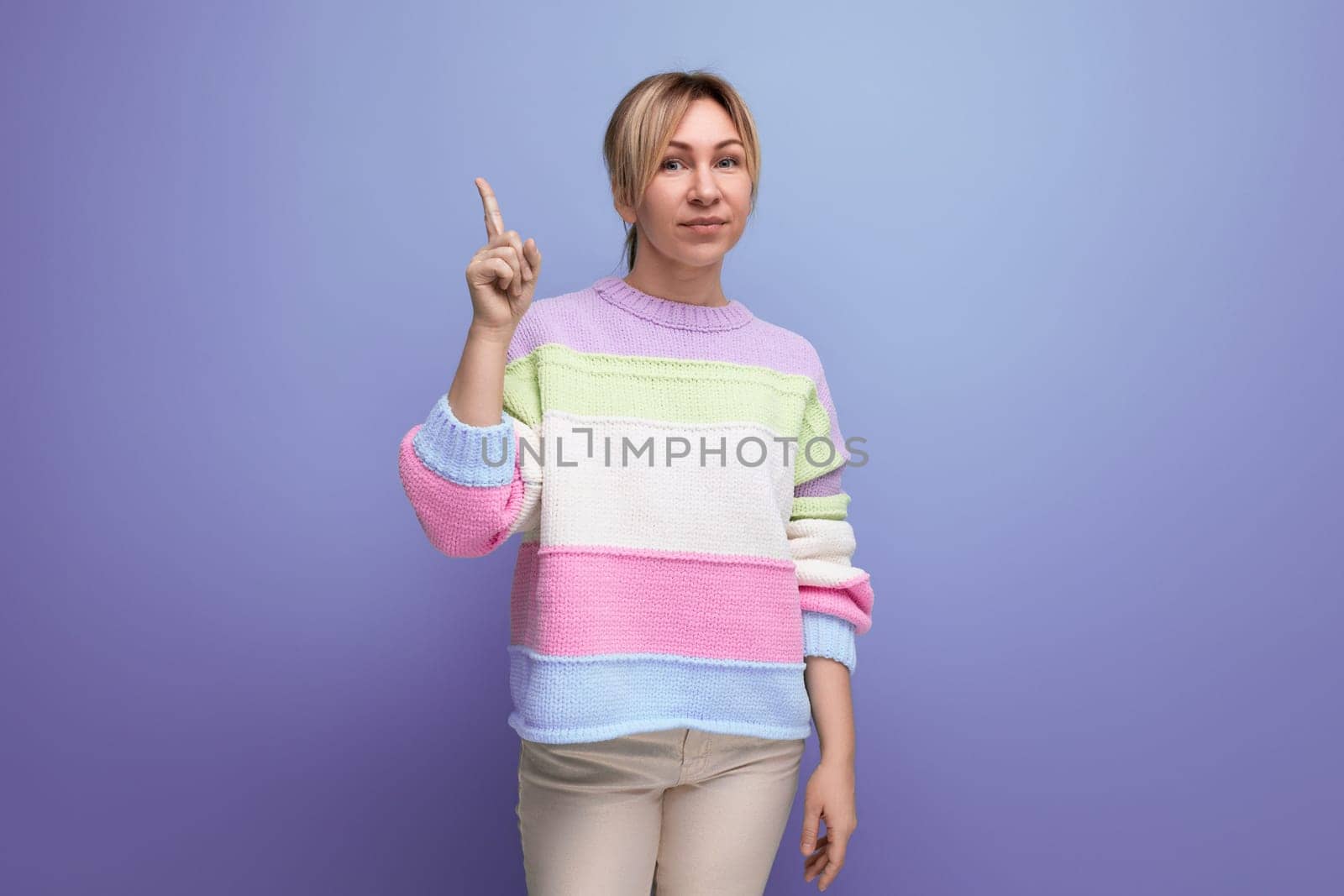 blond brilliant young woman in casual outfit with a good idea on a purple background with copy space.