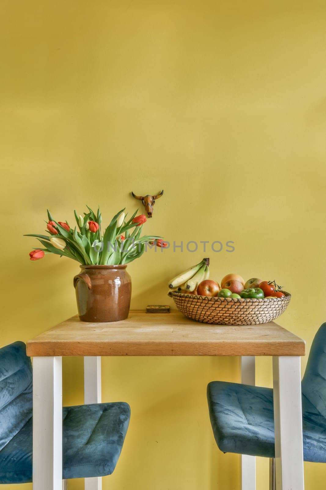 a table with a basket of fruit and a plant by casamedia