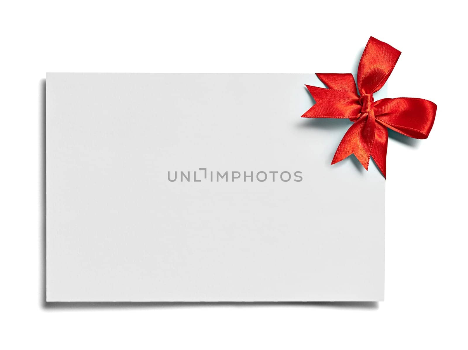 close up of a note card with red ribbon bow on white background