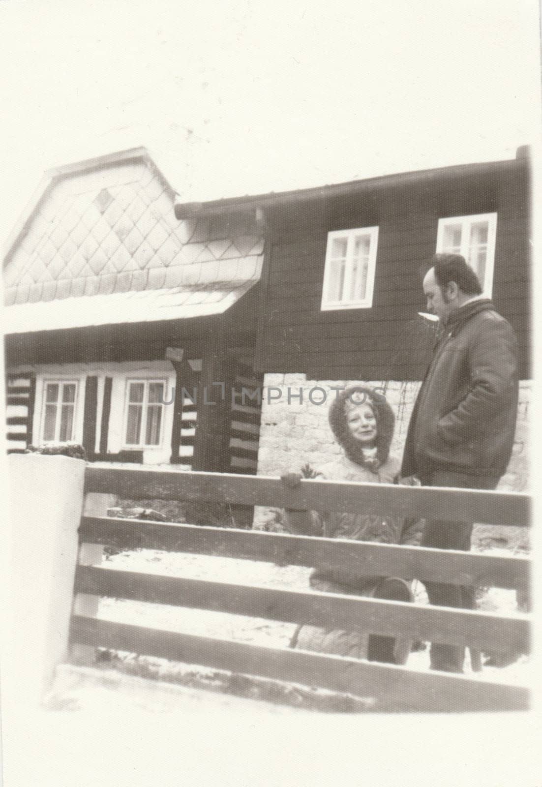 Vintage photo shows people in front of house. Retro black and white photography. Circa 1970s. by roman_nerud