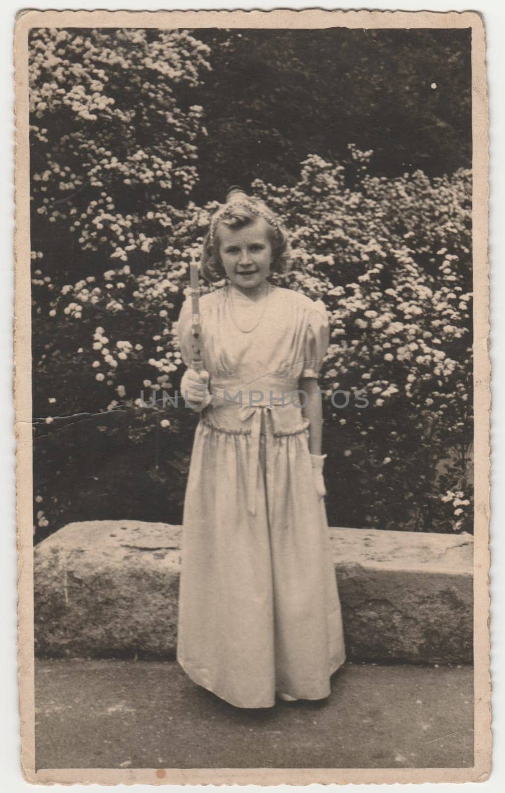 Vintage photo shows girl after her first communion. Retro black and white photography. Circa 1940s. by roman_nerud