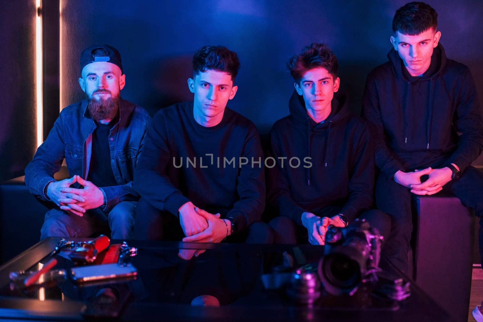 Group of people is together in the studio with futuristic neon lighting.