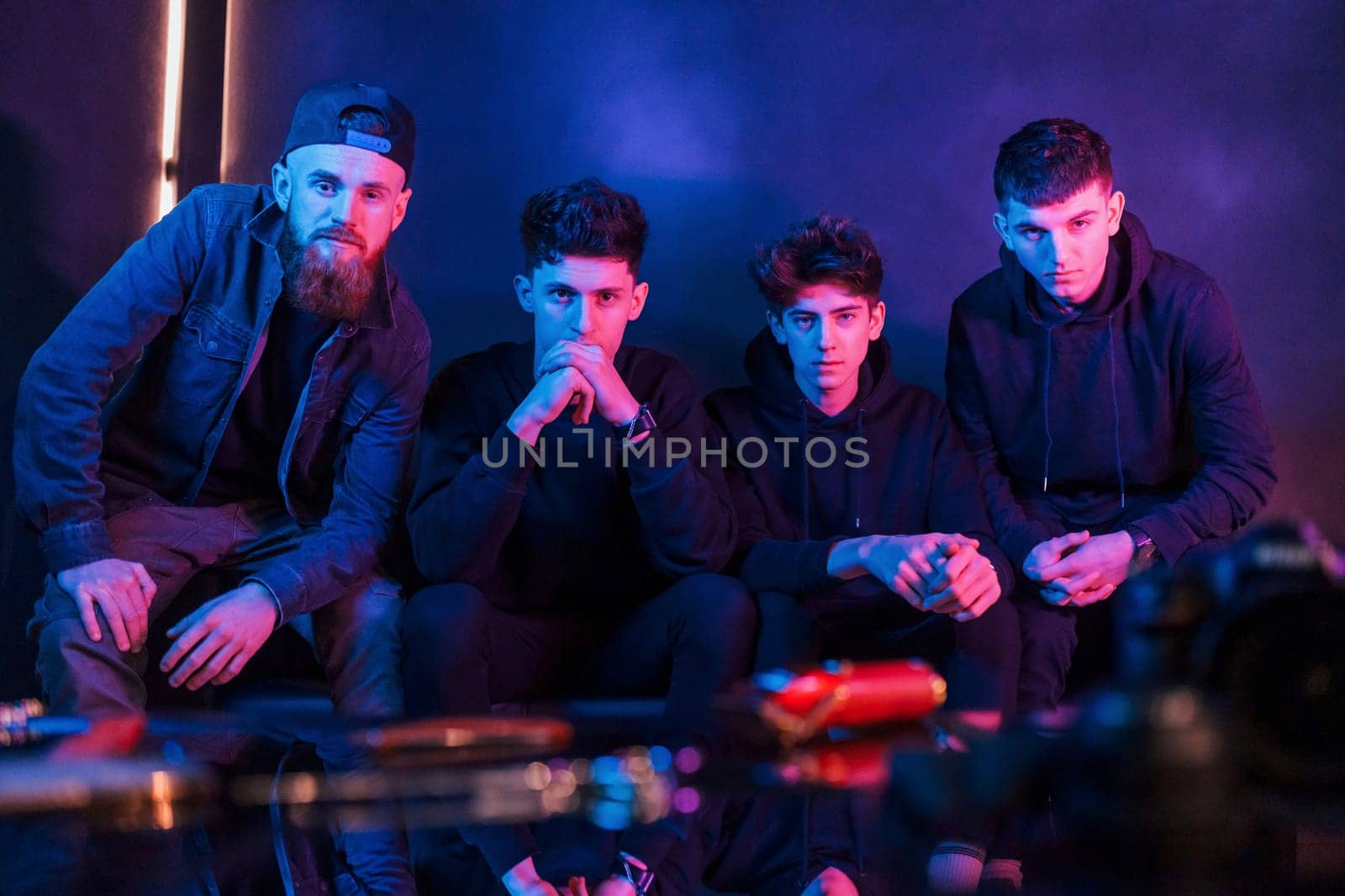Group of people is together in the studio with futuristic neon lighting.