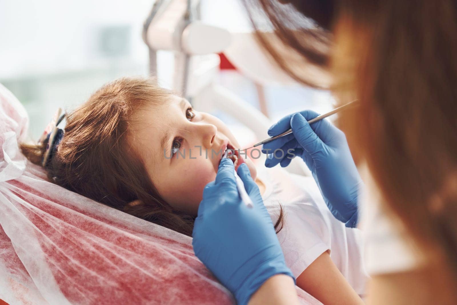 Little girl visiting dentist in clinic. Conception of stomatology.