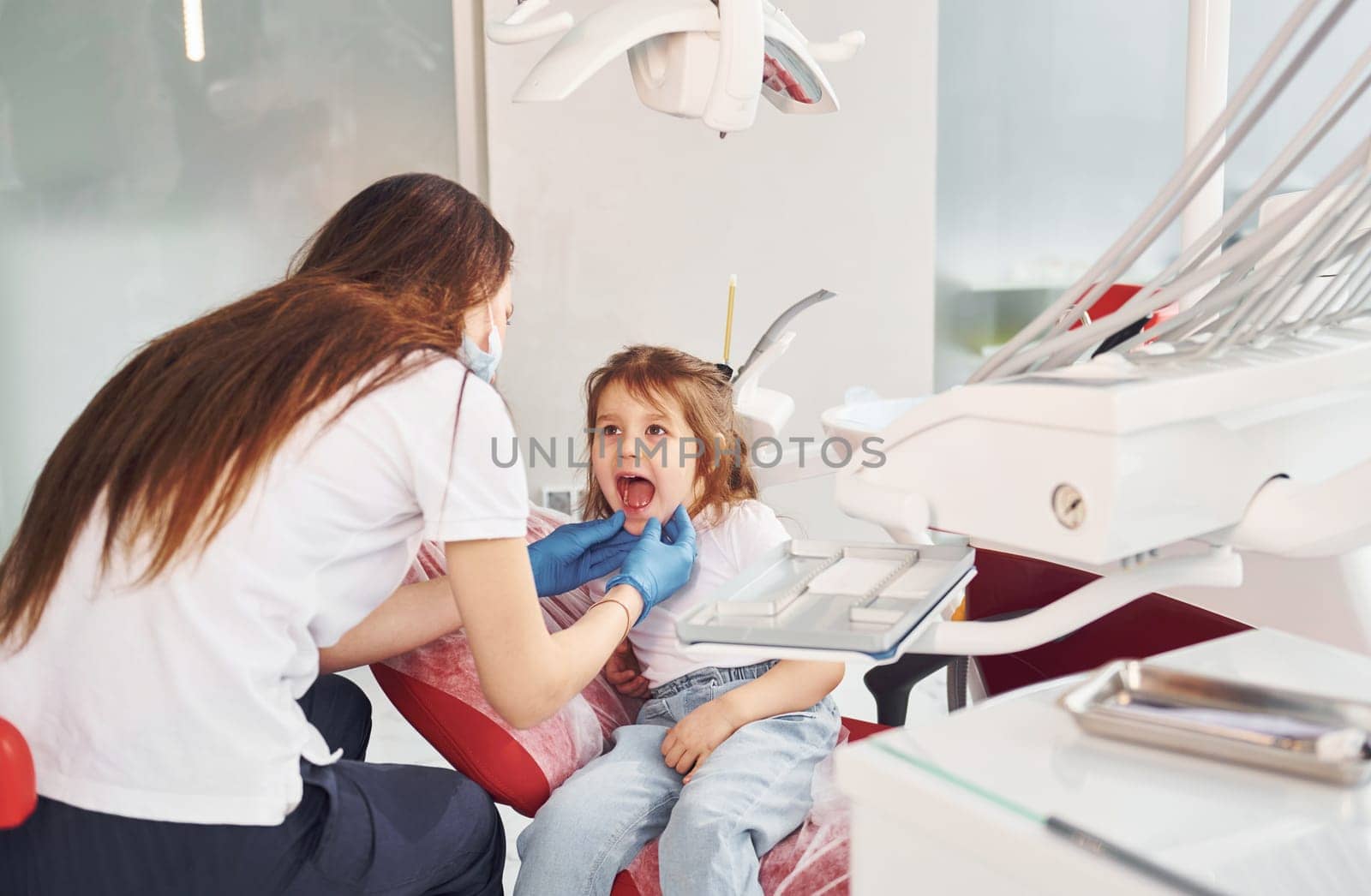 Little girl visiting dentist in clinic. Conception of stomatology.