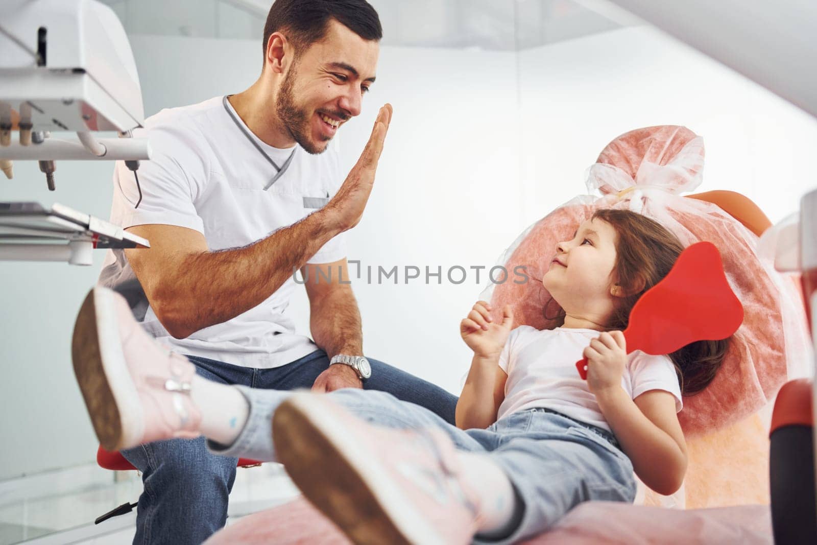 Job well done. Little girl visiting dentist in clinic. Conception of stomatology.