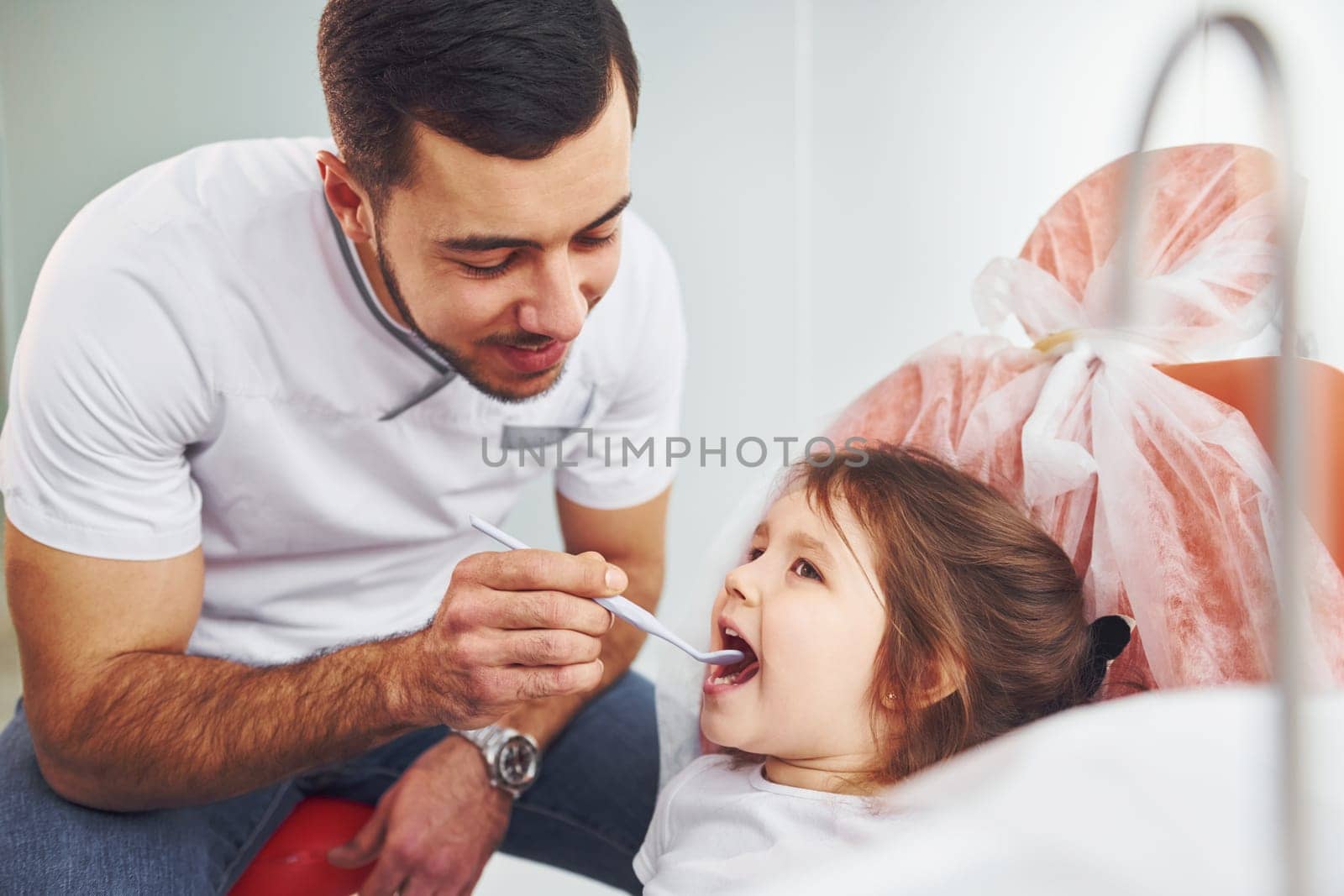 Little girl visiting dentist in clinic. Conception of stomatology.