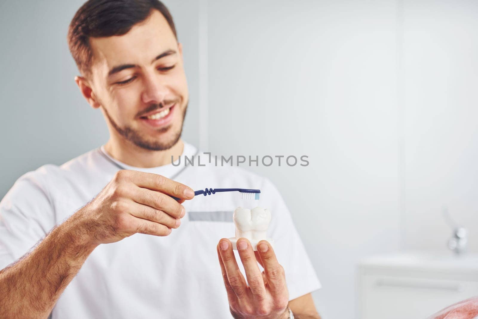 Portrait of professional dentist with equipment that standing indoors by Standret