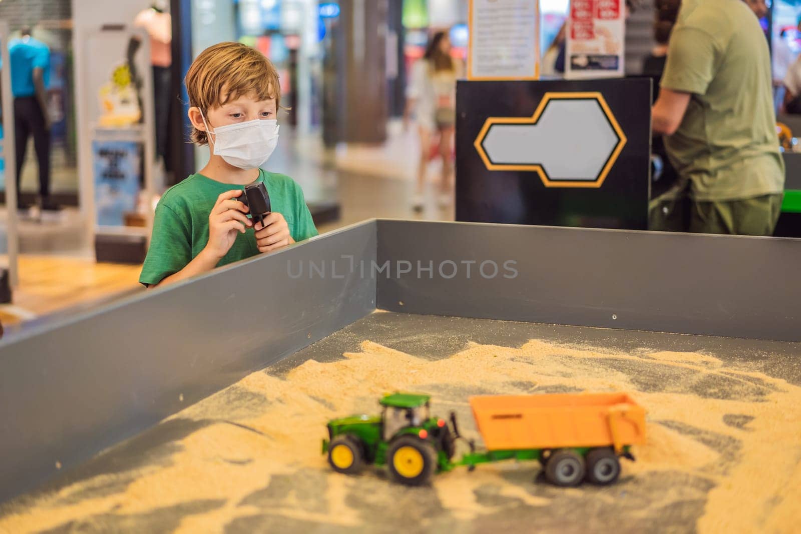Adorable cute little child playing with toy on remote control, in the mall. Happy kid boy having fun. Leisure, lifestyle for kids concept.