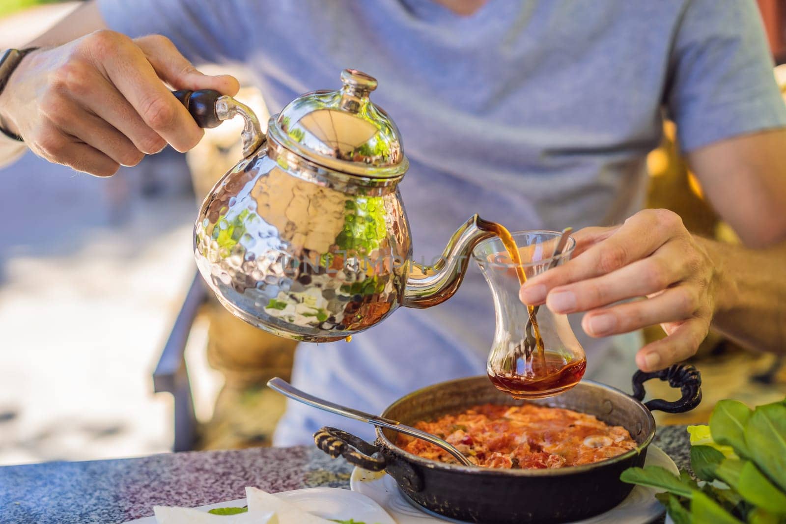 Drinking Traditional Turkish Tea with Turkish tea cup and copper tea pot.