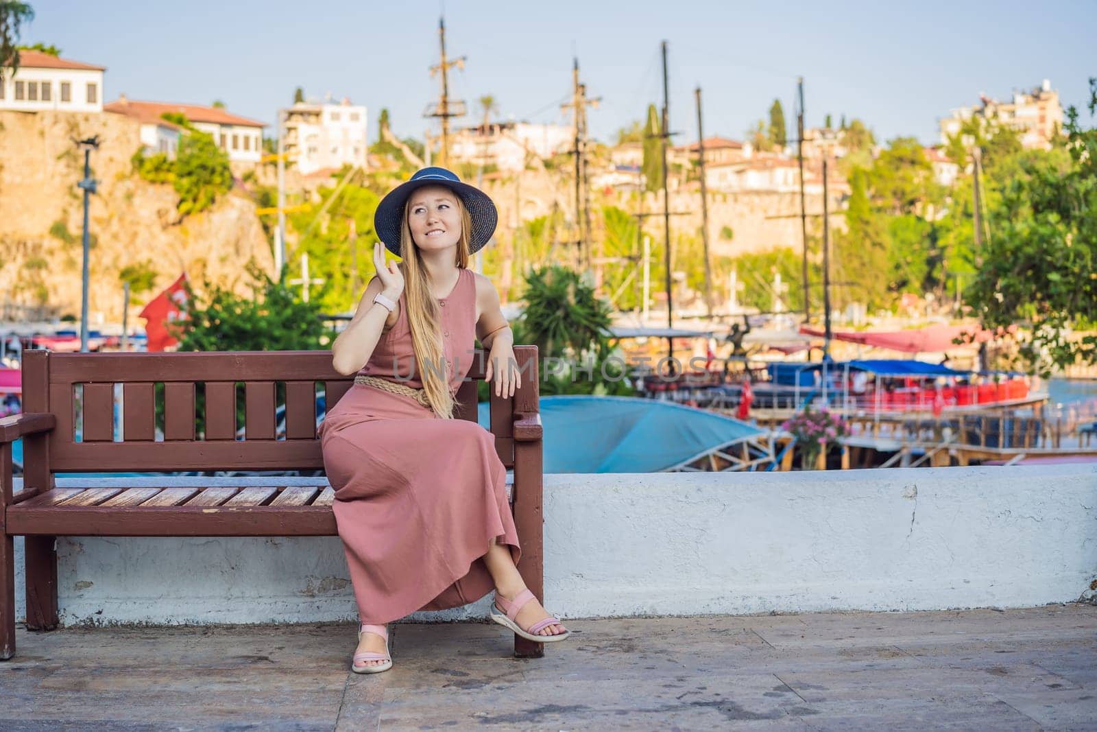 Woman tourist in Old town Kaleici in Antalya. Turkiye. Panoramic view of Antalya Old Town port, Taurus mountains and Mediterrranean Sea, Turkey.