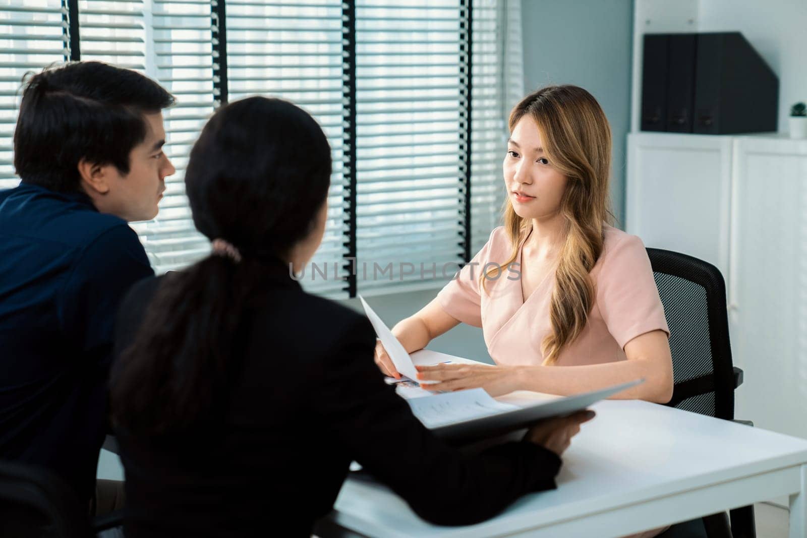 Young female asian candidate tries to impress interviewer by being competent. by biancoblue