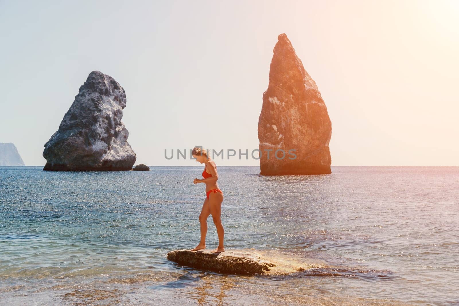 Woman summer travel sea. Happy tourist enjoy taking picture outdoors for memories. Woman traveler posing on the beach at sea surrounded by volcanic mountains, sharing travel adventure journey by panophotograph