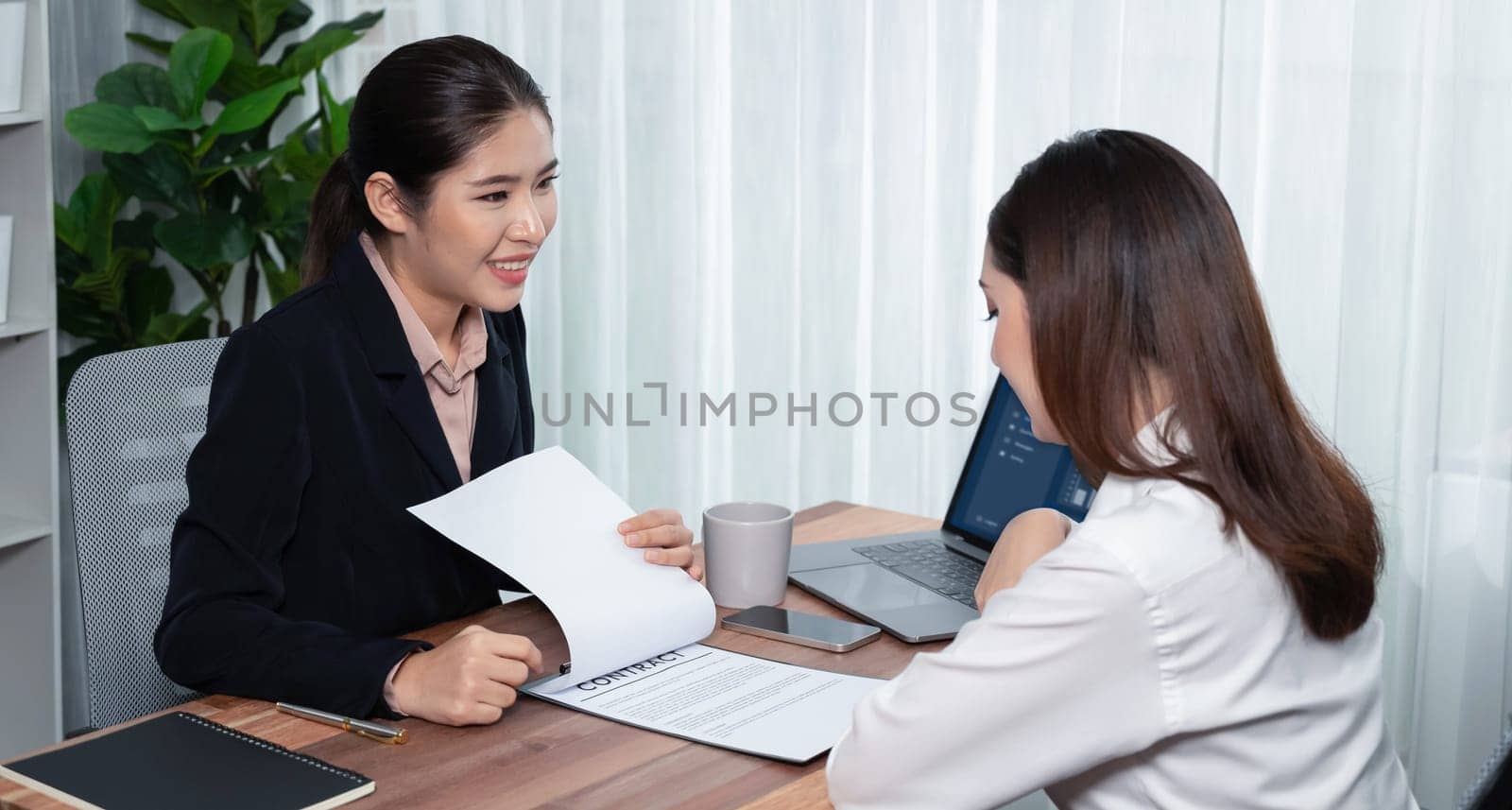 Business deal meeting, young businesswomen carefully reviewing terms and condition of contract agreement papers in office. Corporate lawyer give consultation on contract deal. Enthusiastic