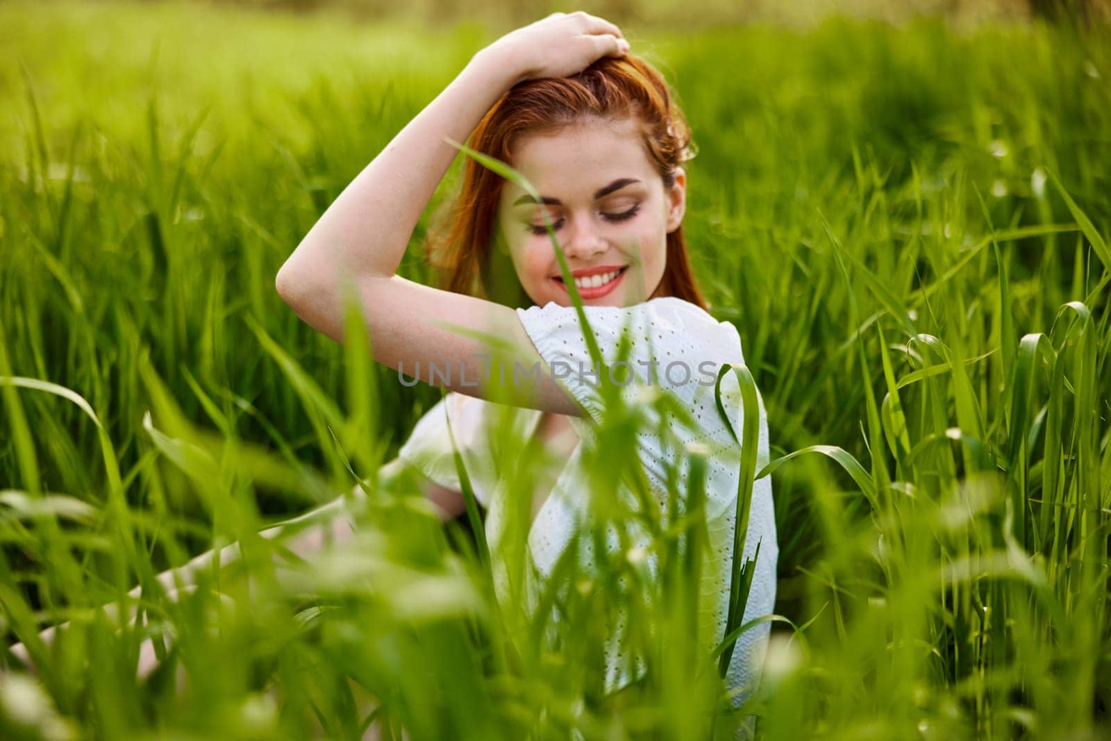 beautiful woman enjoying nature sitting in tall grass. High quality photo