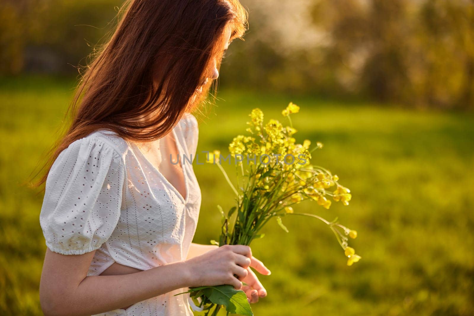 portrait of a woman with a bouquet of wild flowers in the rays of the setting sun in a field by Vichizh