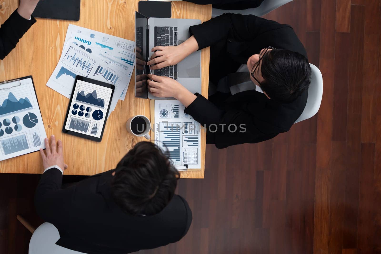 Top-view business team of financial data analysis meeting with business intelligence, report paper and dashboard on laptop for marketing strategy. Business people working together in office of harmony