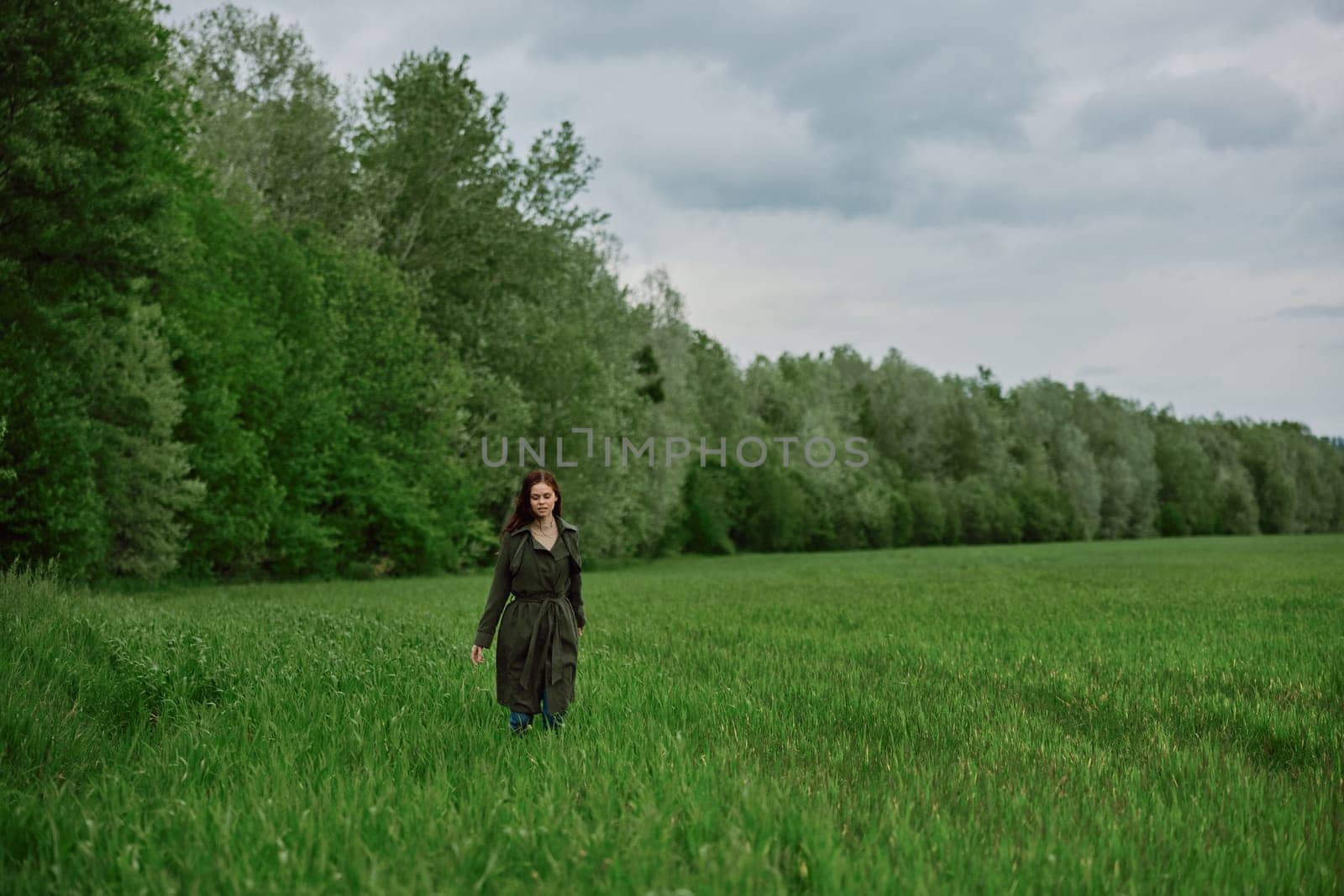 a beautiful, happy woman runs across a green field with flowing red hair. Emotions of happiness by Vichizh