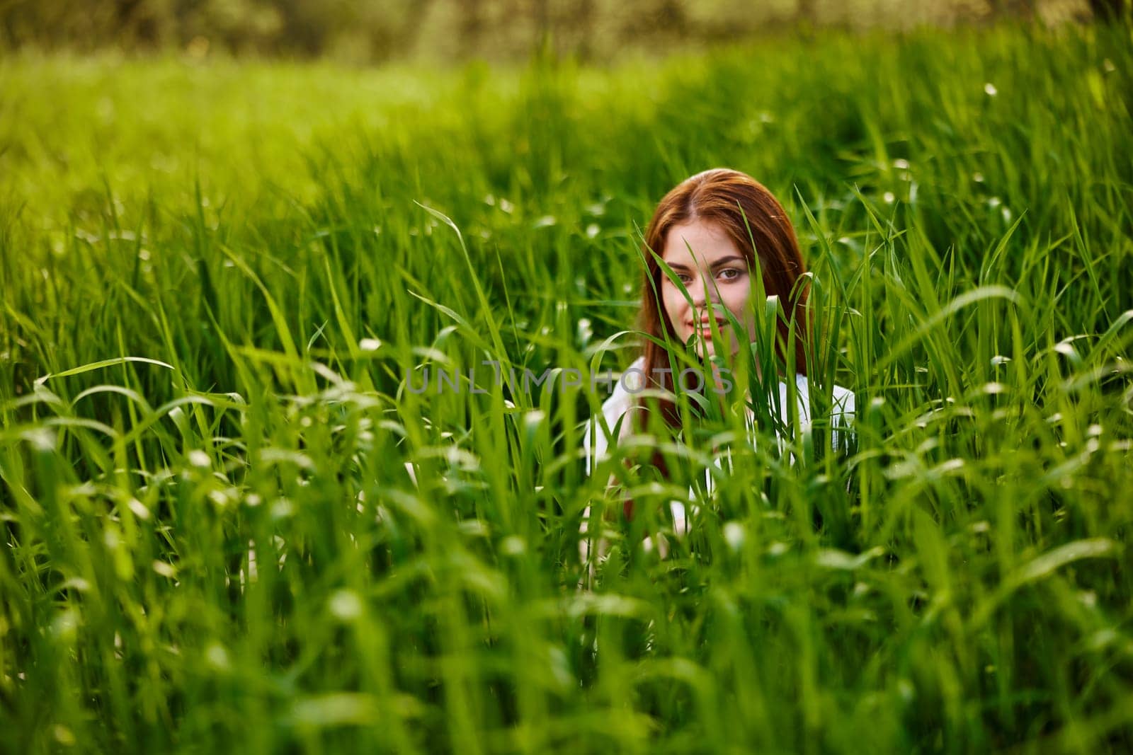 funny woman hiding in tall green grass. High quality photo