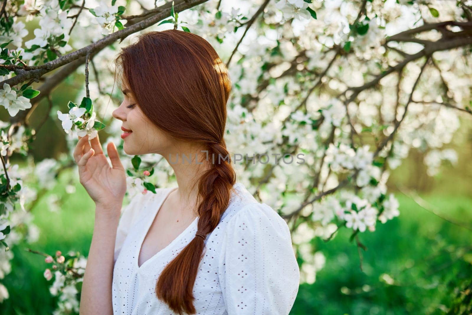 woman with flowers. gorgeous model in the spring garden. the girl near the tree in the spring. the concept of spring. young orchard by Vichizh