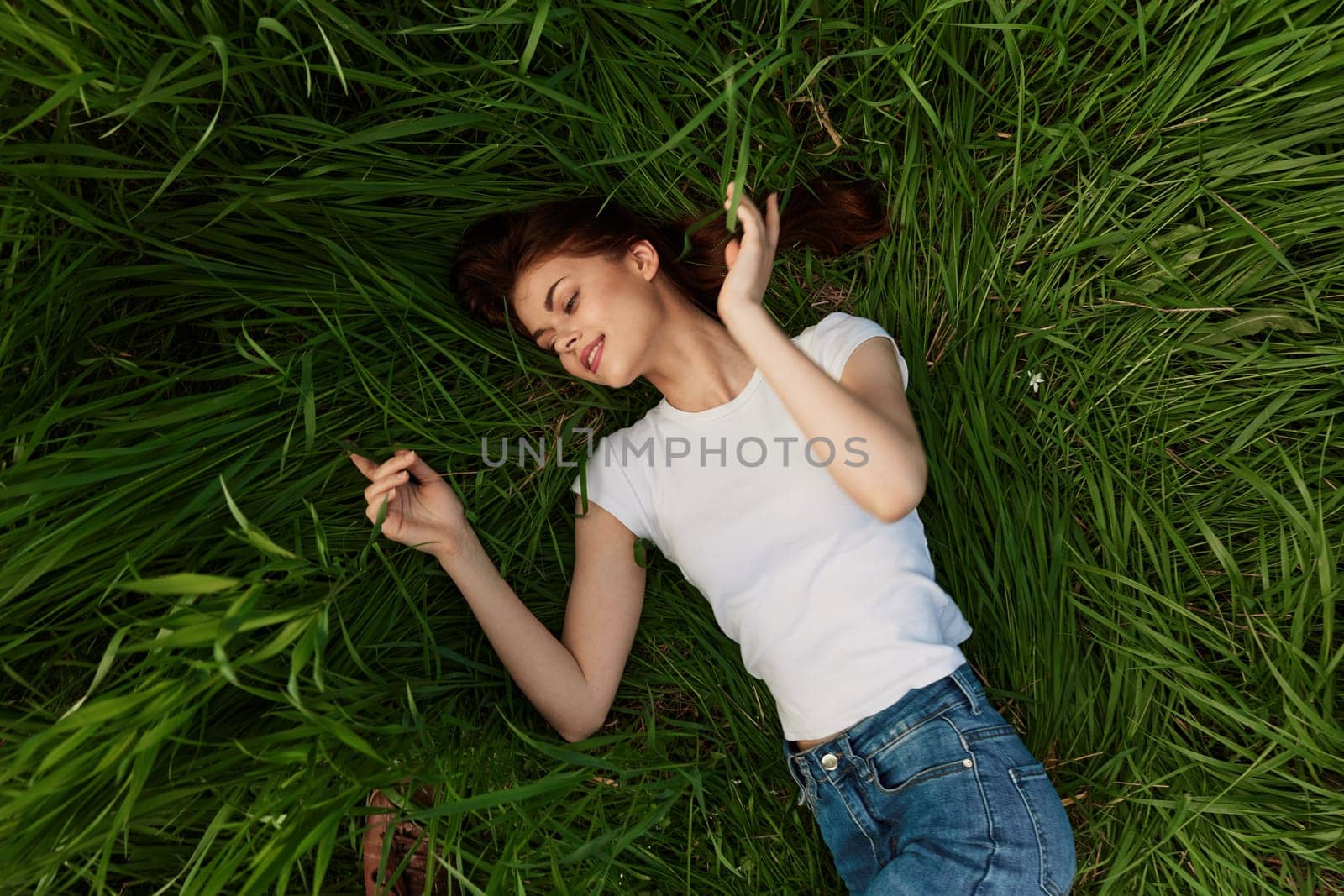 top view of a joyful woman lying in the grass. High quality photo