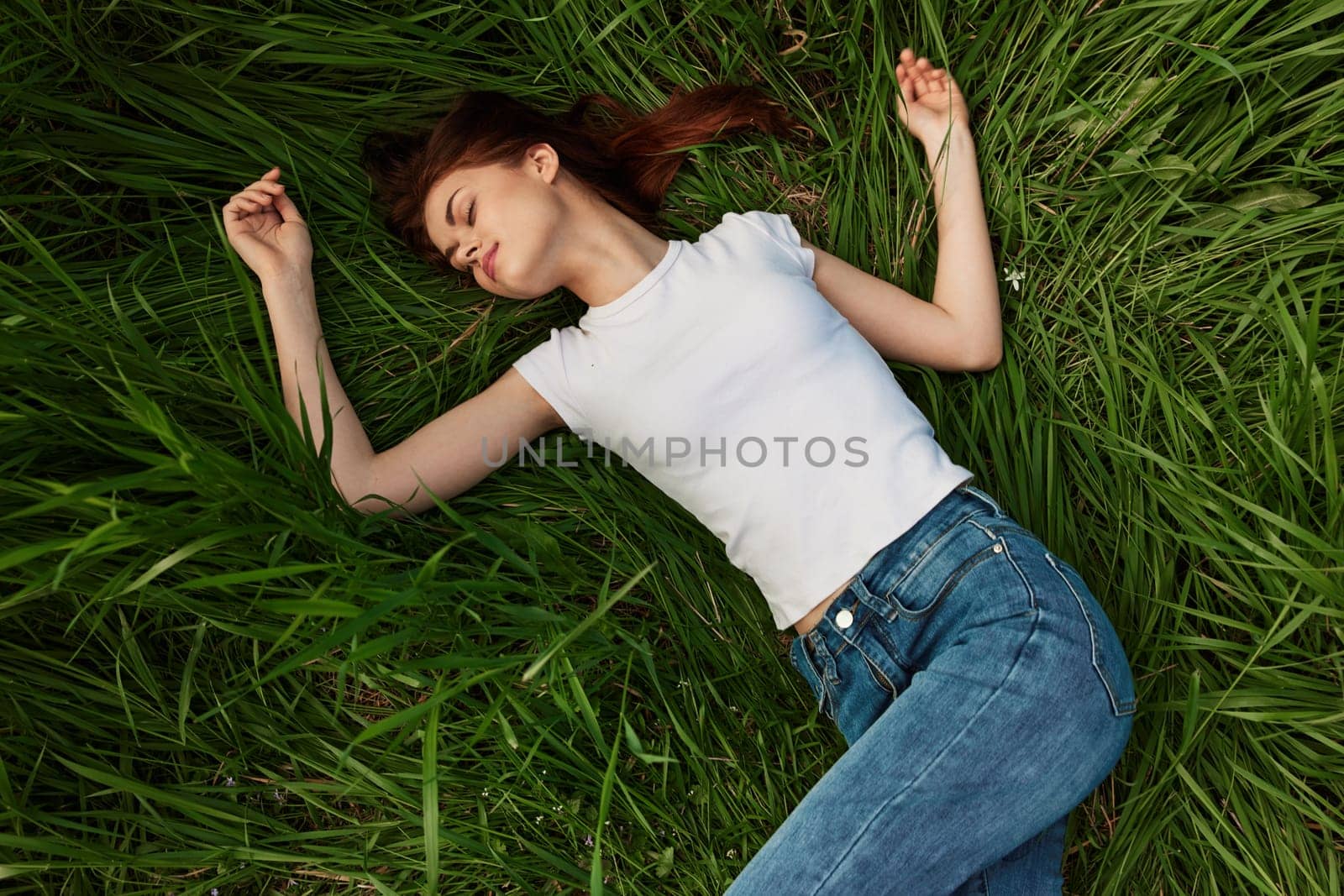 woman lies in tall grass falling asleep in nature. High quality photo