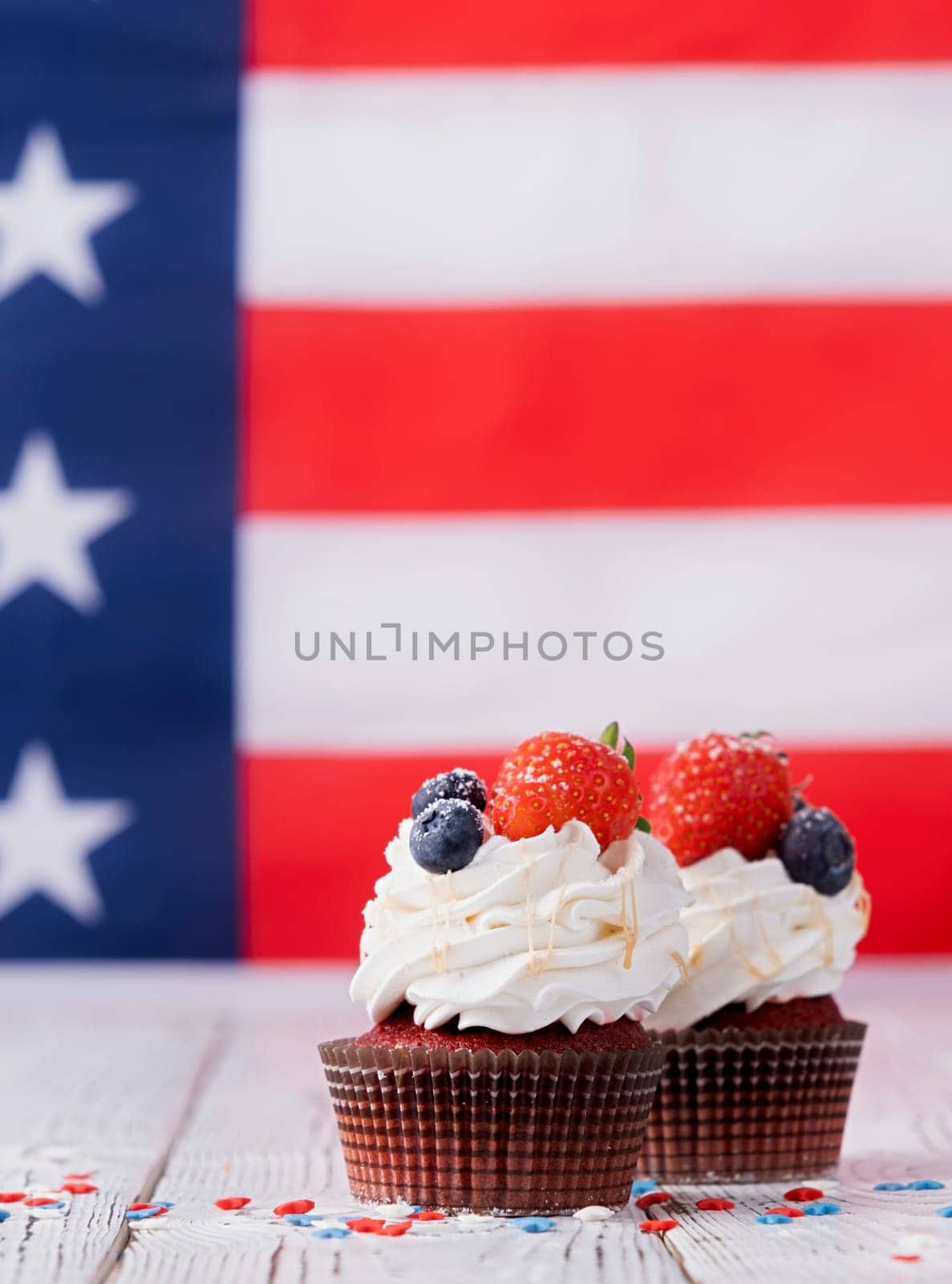 Sweet cupcakes with blueberries and strawberry , flag background by Desperada