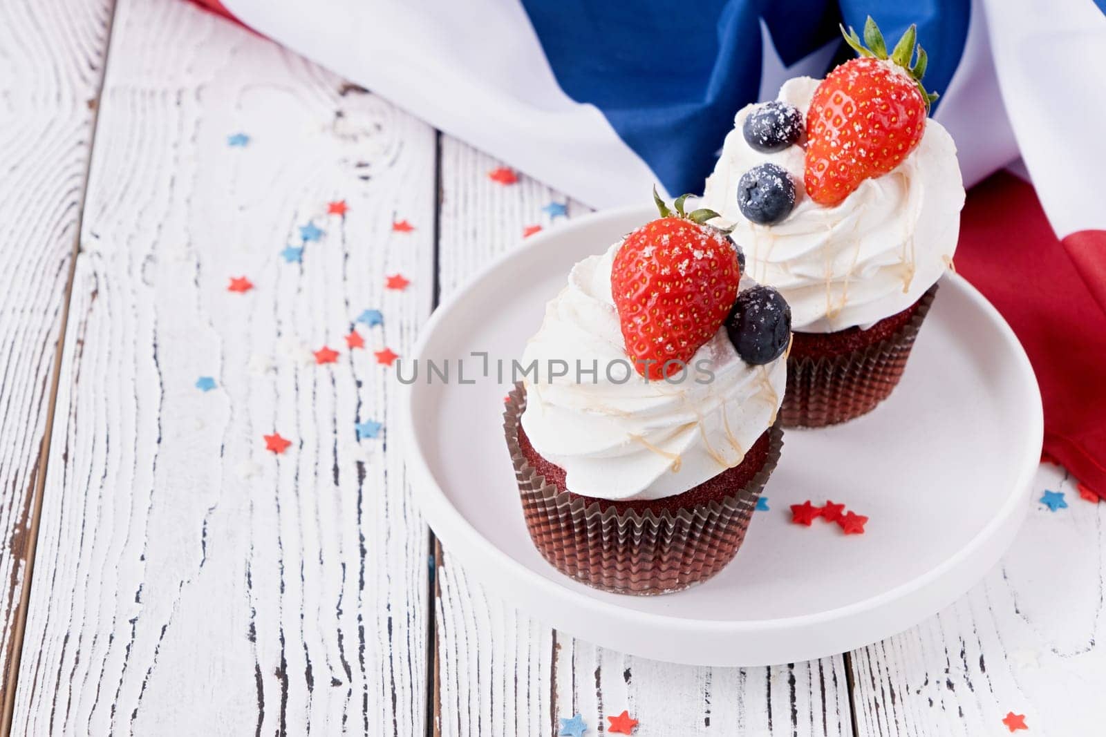 Sweet cupcakes with blueberries and strawberry , flag background by Desperada