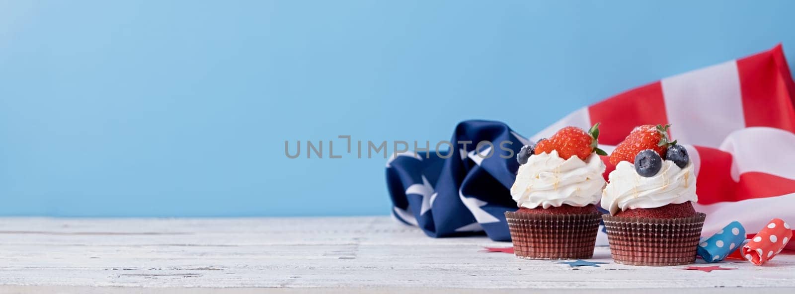 Sweet cupcakes with blueberries and strawberry , usa flag on blue background by Desperada