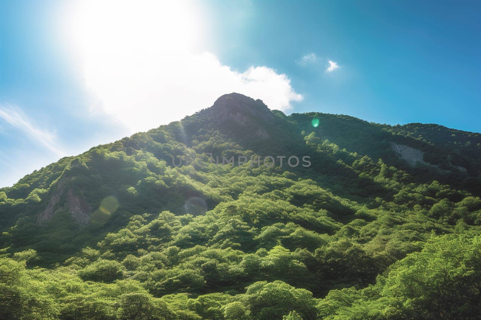 Beautiful sunrise over the green mountains in morning light with fluffy clouds on a bright blue sky. Nature freshness concept.