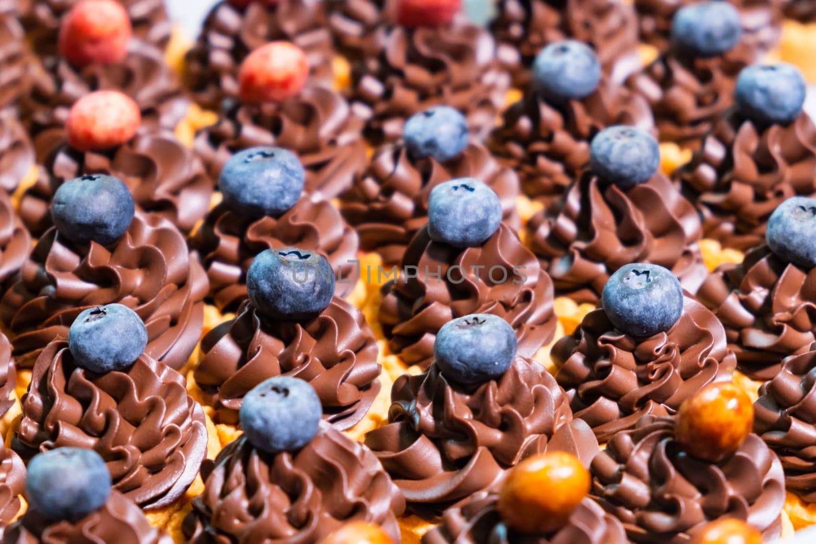 Cupcakes with cream decorated with berries. Concept of candy bar for birthday party, wedding, 8 march, Mother Day, St Valentines Day.