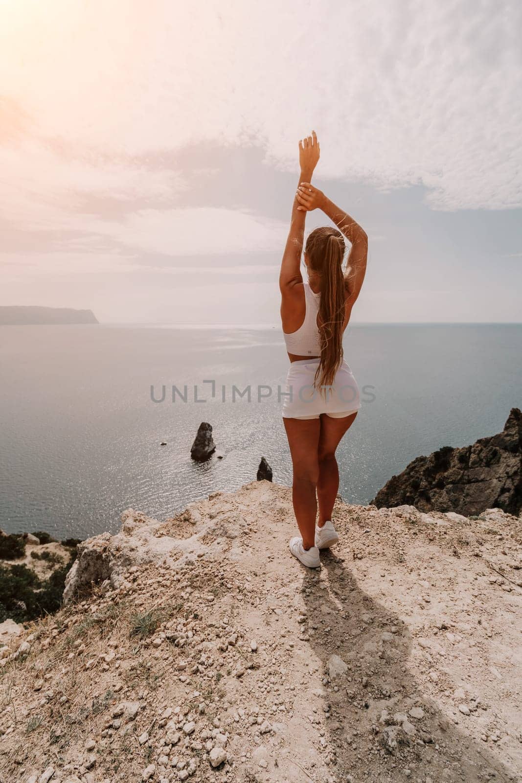 Woman travel sea. Happy tourist in hat enjoy taking picture outdoors for memories. Woman traveler posing on the beach at sea surrounded by volcanic mountains, sharing travel adventure journey
