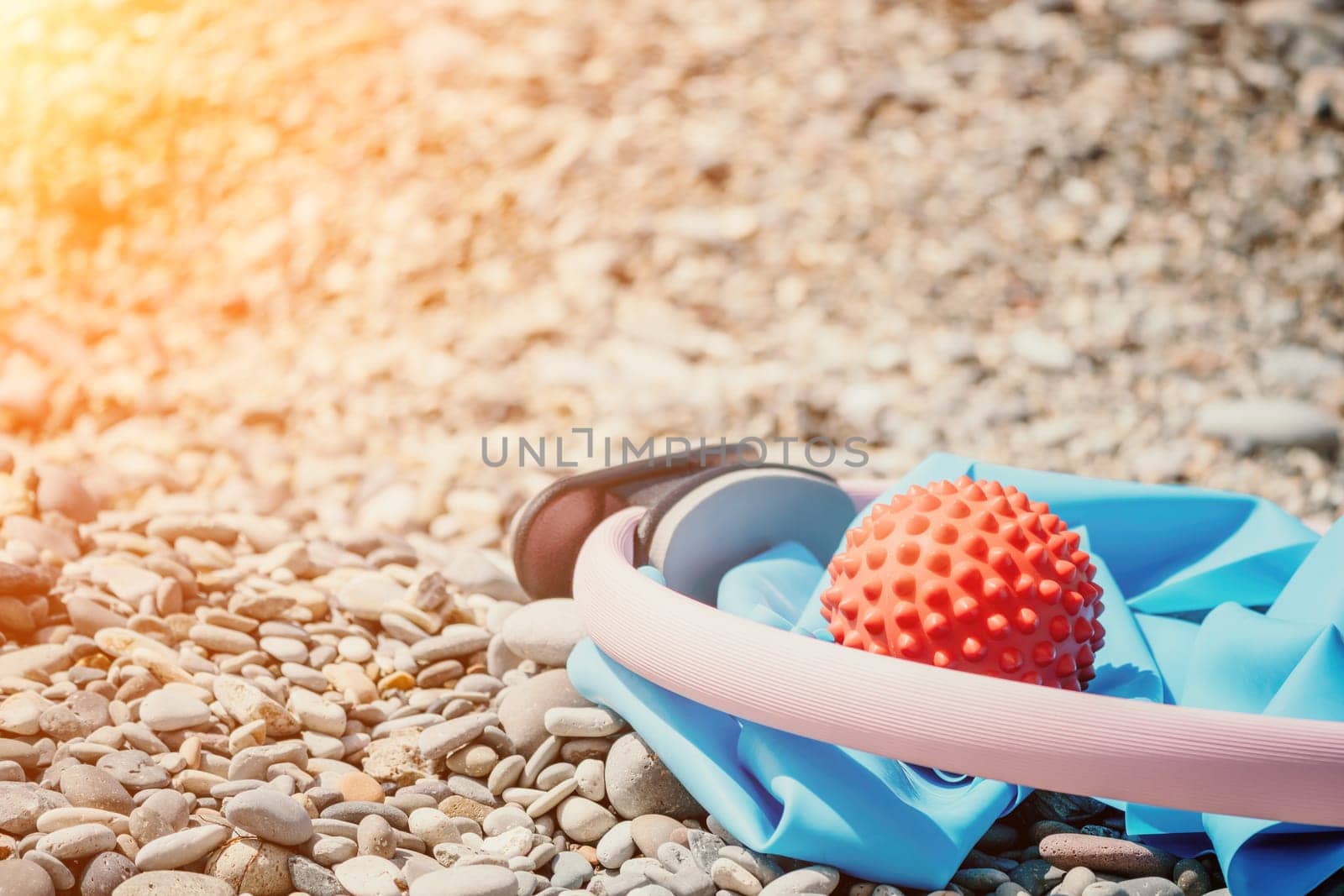 Pilates magic ring and rubber band on yoga mat near sea. Female fitness yoga concept. Healthy lifestyle harmony and meditation. by panophotograph