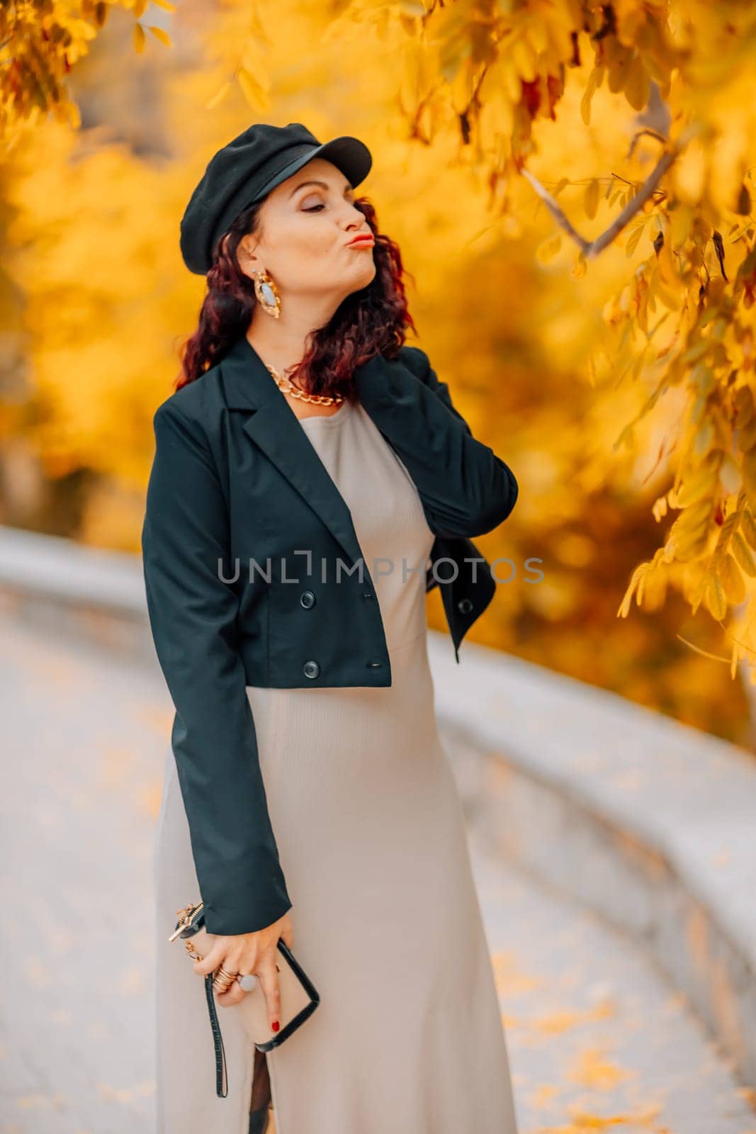 A woman walks outdoors in autumn, enjoys the autumn weather