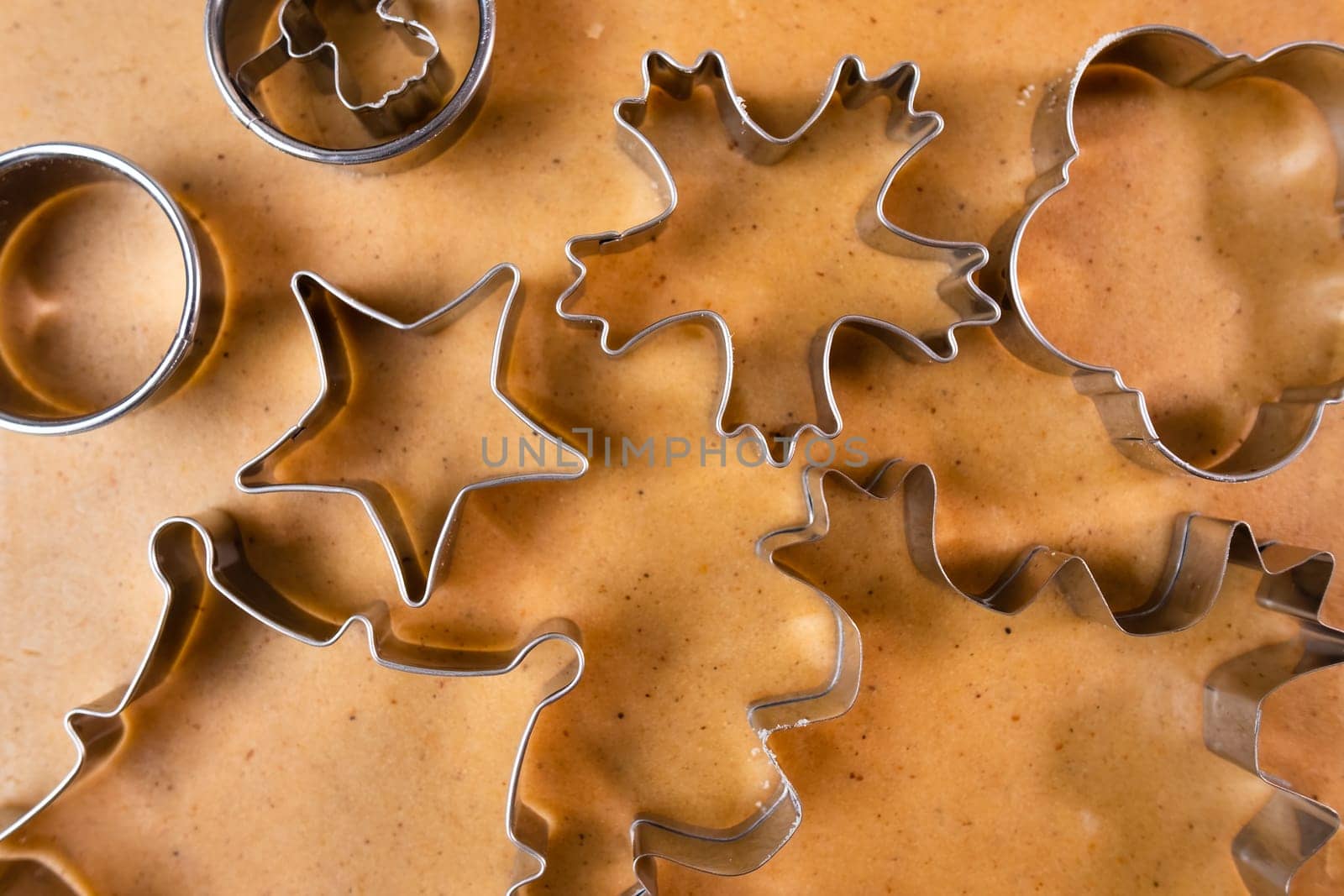 Cutting out cookies with metal mold from the shortcrust pastry. A metal forms in the form of snowflakes for making gingerbread for Christmas.