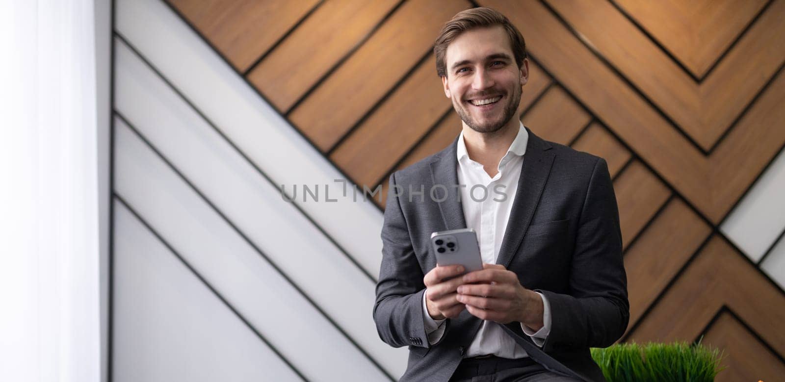 male head in a business suit with a phone in the office.