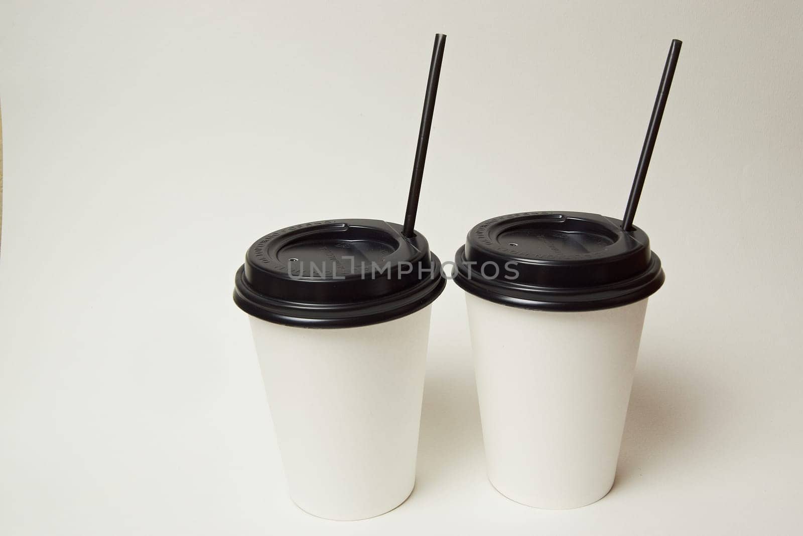 Paper coffee container with black lid and coffee beans on a white background white coffee paper cup with black lid takeaway coffee