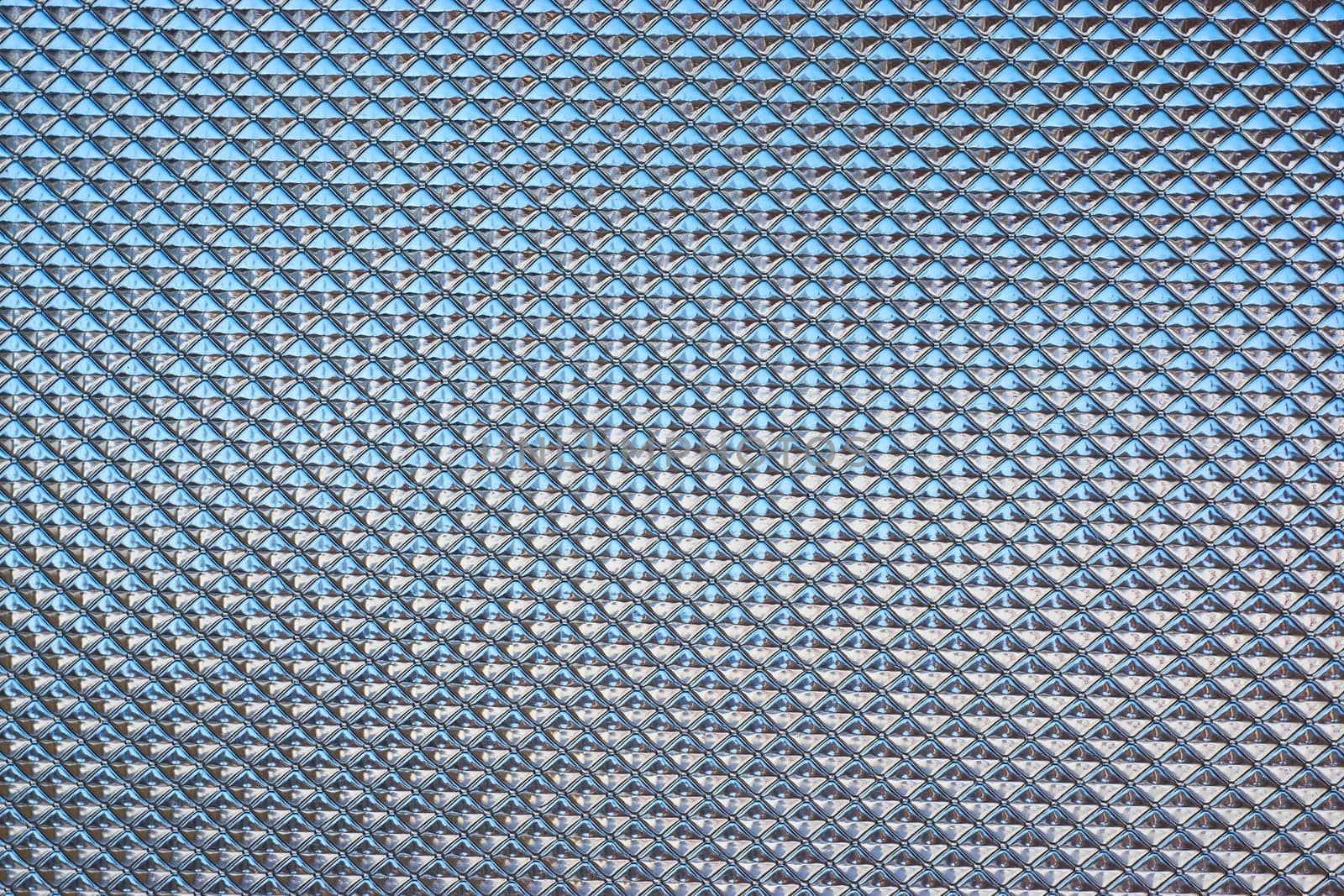 glass with a corrugated relief background of light blue color