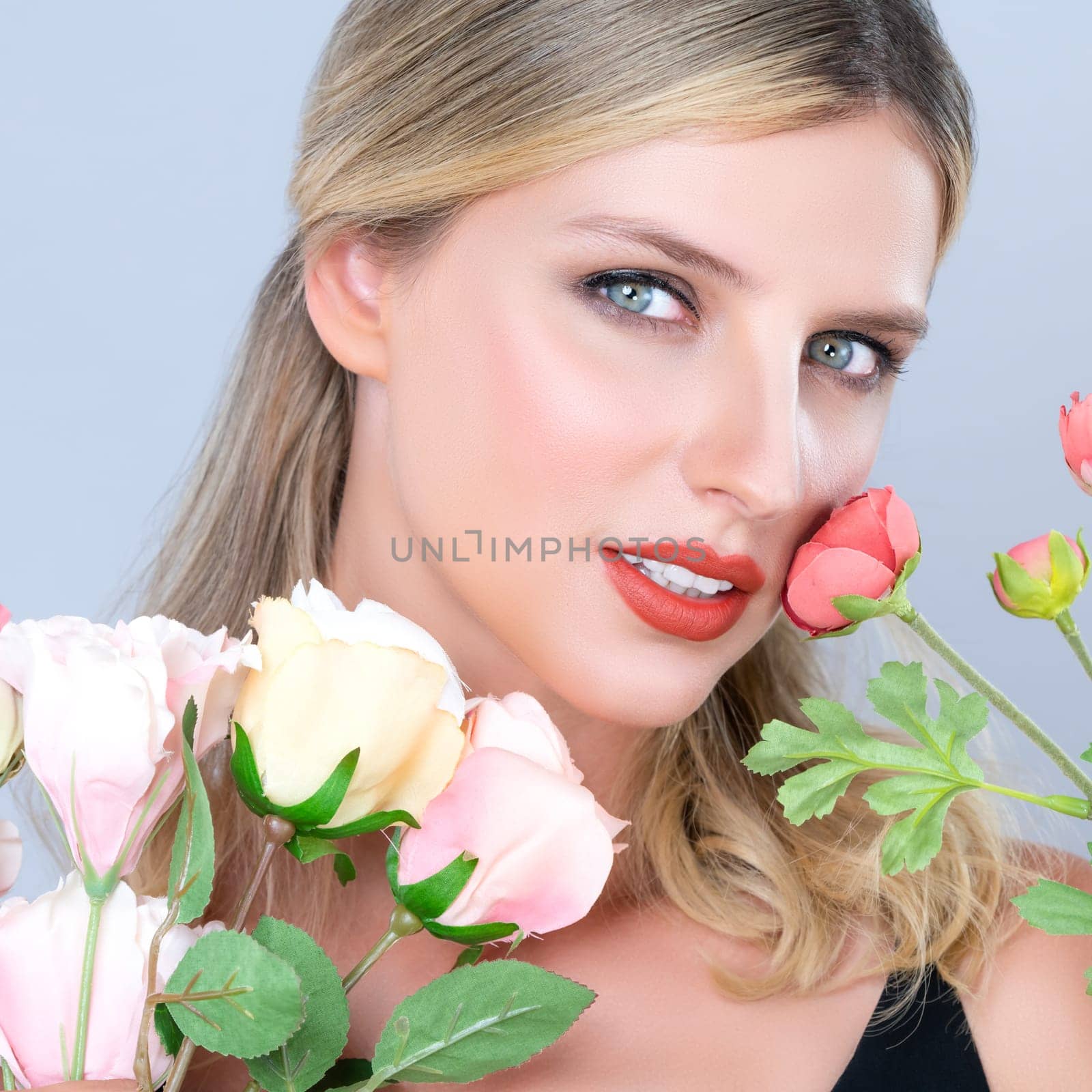 Closeup young woman with alluring flawless makeup and healthy soft skin holding rose for natural skincare treatment advertising in isolated background. Beautiful pretty model girl with flower concept.