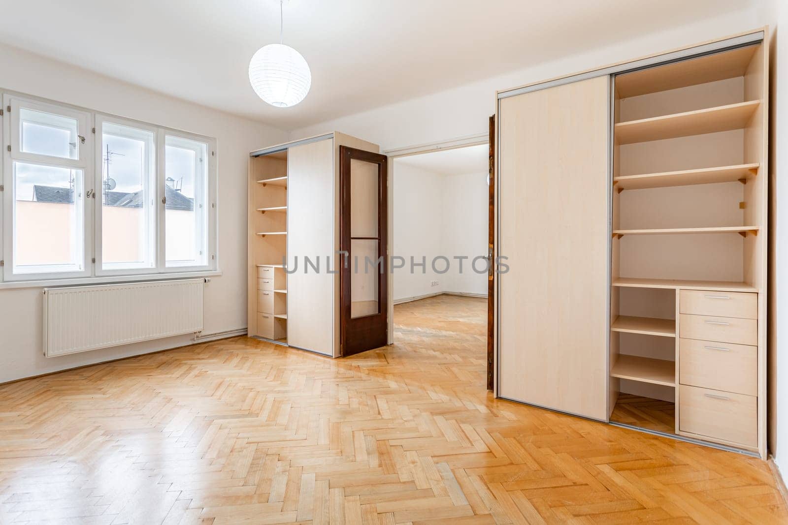 an empty room in an apartment with a wardrobe and a wooden parquet floor. High quality photo