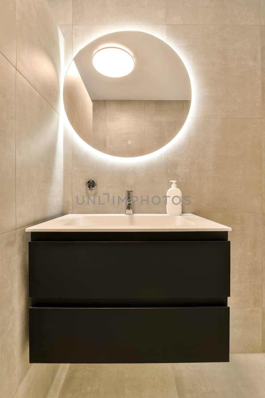 a bathroom with a sink and mirror on the wall next to it is an illuminated round light above the sink