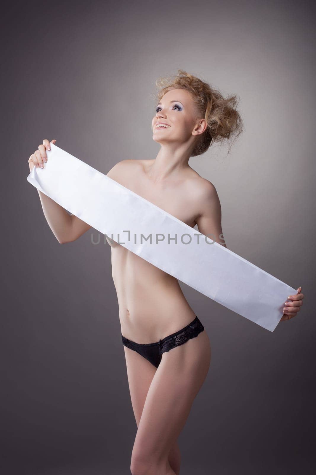 Merry slender girl covers her nudity with tape, close-up