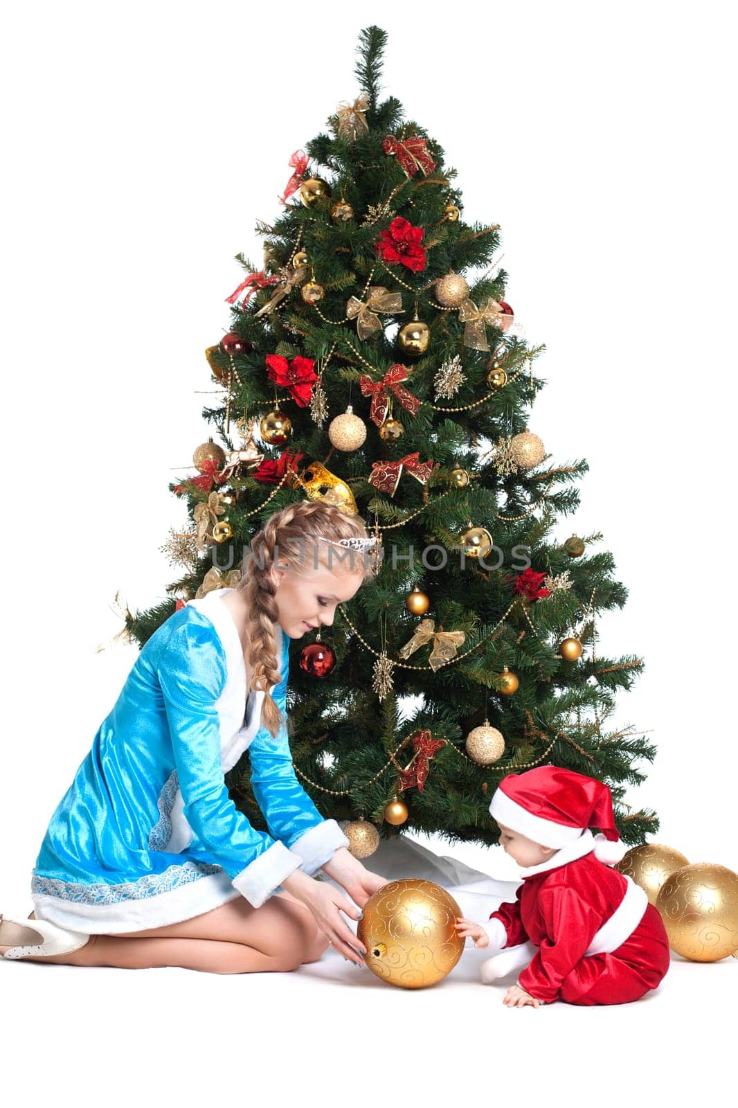 Snow Maiden and baby-Santa posing near Christmas tree