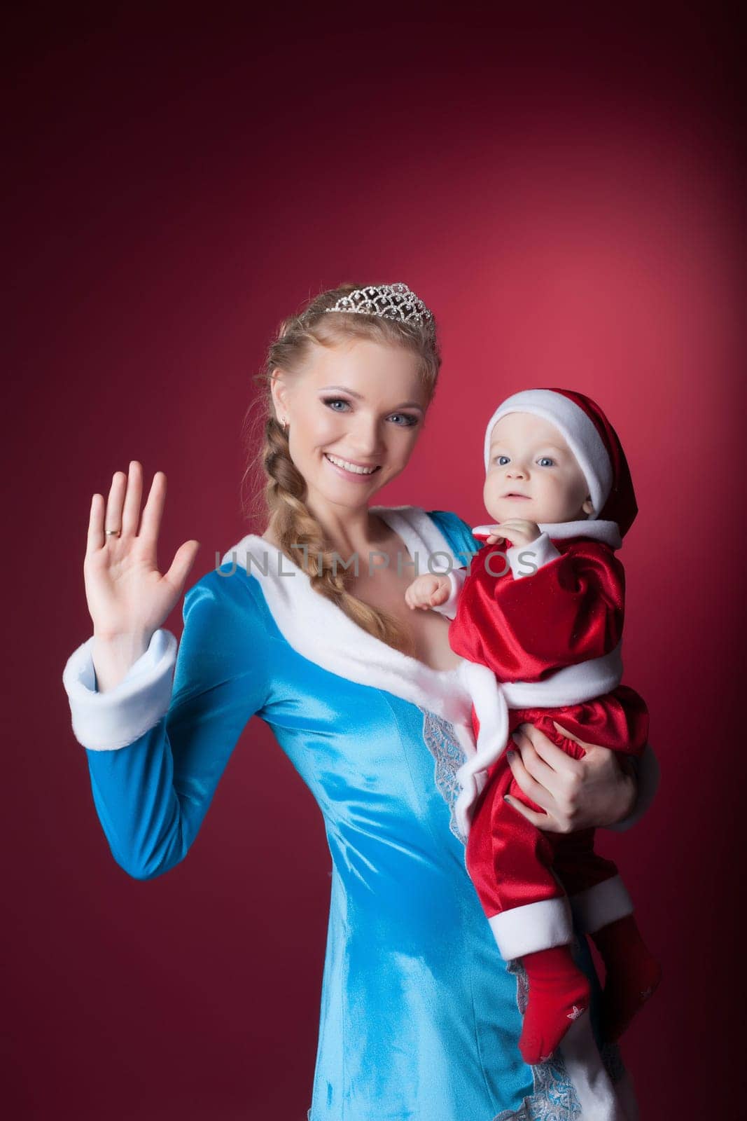 Happy mom-Snow Maiden holds baby-Santa Claus, on pink background